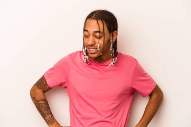 Beyaz arka planda izole edilmiş genç Afrikalı Amerikalı adam mutlu bir şekilde gülüyor ve ellerini karnının üstünde tutarak eğleniyor..