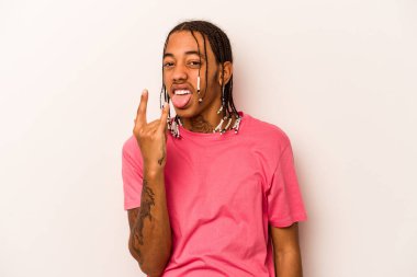 Beyaz arka planda izole edilmiş genç Afrikalı Amerikalı parmaklarıyla kaya hareketi gösteriyor.