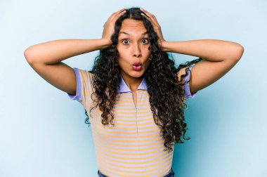 Mavi arka planda izole edilmiş genç İspanyol kadın şok geçiriyordu. Önemli bir buluşmayı hatırladı..