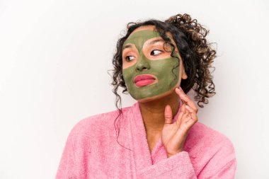 Beyaz arka planda izole edilmiş yüz maskesi takan genç İspanyol kadın.