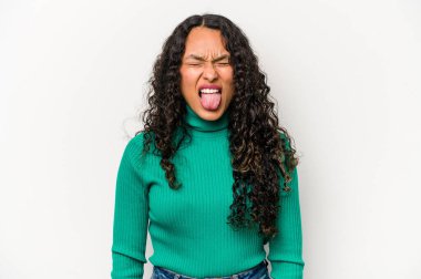 Beyaz arka planda izole edilmiş genç bir İspanyol kadın. Komik ve dost canlısı bir dil uzatıyor..