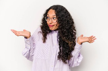 Beyaz arka planda izole edilmiş genç İspanyol bir kadın. Kafası karışmış ve omuz silkiyor. Kopya alanını tutmak için..