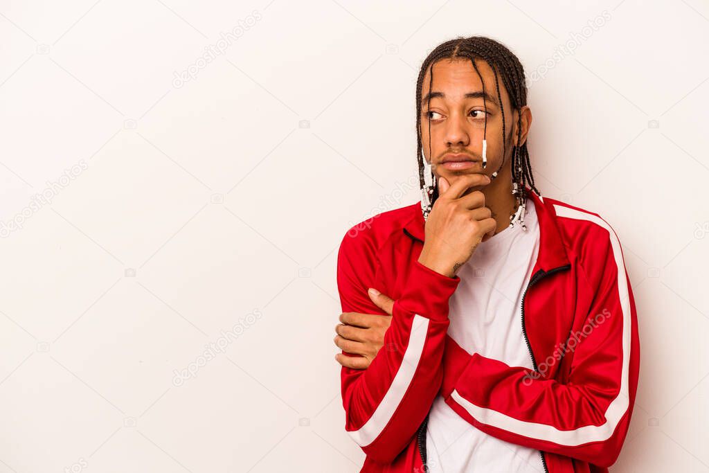 Young African American man isolated on white background relaxed thinking about something looking at a copy space.