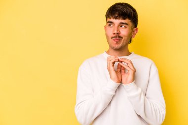 Kafkasyalı genç bir adam sarı arka planda izole edildi. Aklında bir plan oluşturdu..