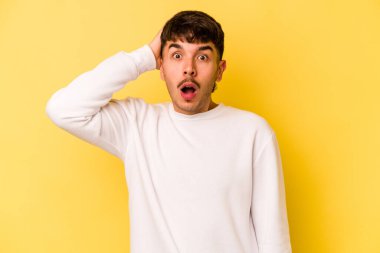 Sarı arka planda izole genç beyaz adam şok oldu, o önemli bir toplantı hatırladı.