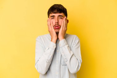 Kafkasyalı genç adam sarı arka planda izole edilmiş sızlanıyor ve ağlıyordu..