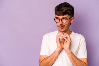 Kafkasyalı genç bir adam mor arka planda izole edilmiş bir plan yapıyor, bir fikir kuruyor..