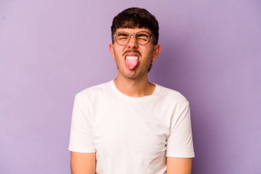 Mor arka planda izole edilmiş beyaz bir genç. Komik ve dost canlısı bir dil..