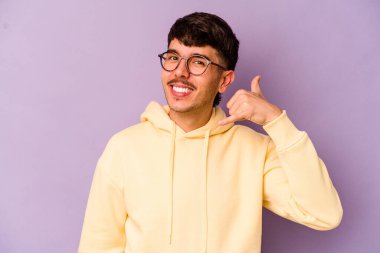 Mor arka planda izole edilmiş genç beyaz adam parmakları olan bir cep telefonu hareketi gösteriyor..