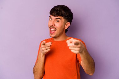 Mor arka planda izole edilmiş genç beyaz adam öne bakan neşeli gülücükler.