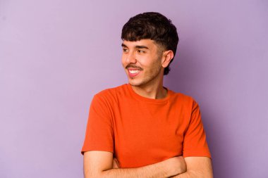 Mor arka planda izole edilmiş genç beyaz adam gülüyor ve eğleniyor..