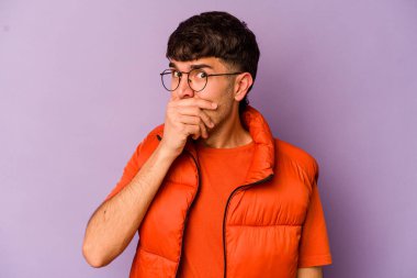 Mor arka planda izole edilmiş genç beyaz adam elleri ve ağzı endişeli görünüyor..