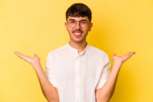 Νεαρός Καυκάσιος Άνδρας Απομονωμένος Κίτρινο Φόντο Κάνει Κλίμακα Χέρια Αισθάνεται — Φωτογραφία Αρχείου