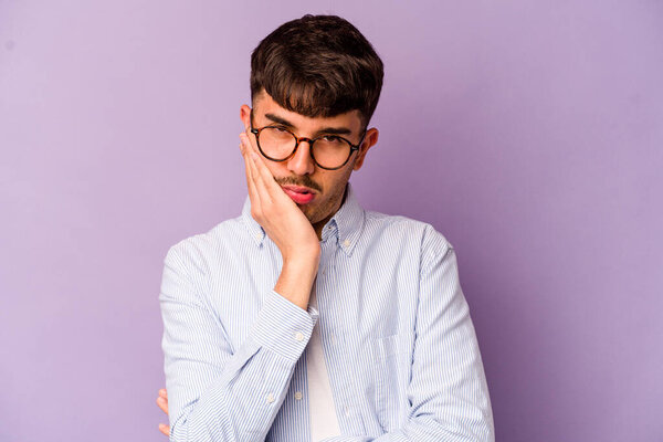 Young caucasian man isolated on purple background who is bored, fatigued and need a relax day.