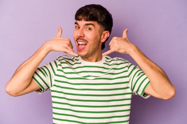 Mor arka planda izole edilmiş genç beyaz adam parmakları olan bir cep telefonu hareketi gösteriyor..