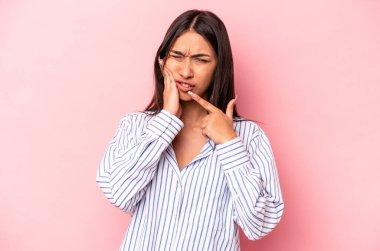 Pembe arka planda izole edilmiş genç İspanyol kadın güçlü bir diş ağrısı, azı dişi ağrısı var..