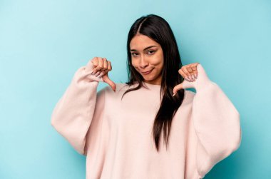 Mavi arka planda izole edilmiş genç İspanyol kadın gururlu ve kendinden emin hissediyor, örnek olarak.