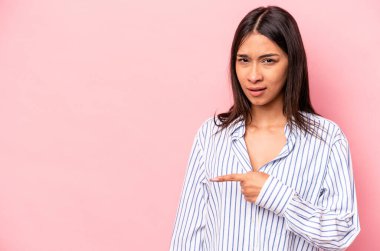 Pembe arka planda izole edilmiş genç İspanyol kadın yan tarafı gösteriyor.