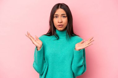 Pembe arka planda izole edilmiş genç İspanyol kadın şaşırdı ve şok oldu..