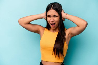 Genç İspanyol kadın mavi arka planda izole edilmiş bağırıyor, çok heyecanlı, tutkulu, bir şeyden memnun..