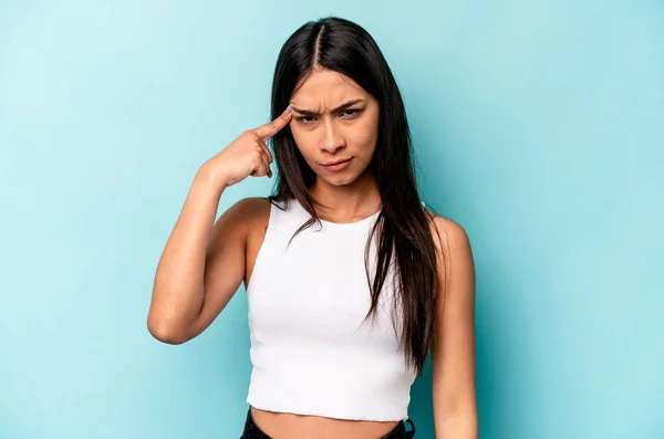 Jonge Spaanse Vrouw Geïsoleerd Blauwe Achtergrond Wijzende Tempel Met Vinger — Stockfoto