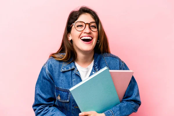 Genç beyaz kadın pembe arka planda izole edilmiş gülüyor ve eğleniyor..