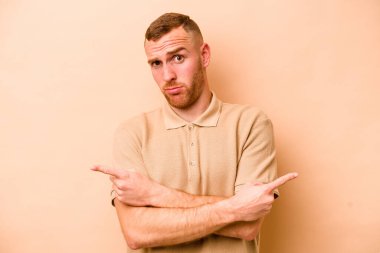 Beyazların arka plan noktalarında izole edilmiş genç beyaz adam iki seçenek arasında seçim yapmaya çalışıyor..