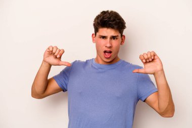 Beyaz arka planda izole edilmiş genç beyaz adam gururlu ve kendinden emin hissediyor, örnek olarak..