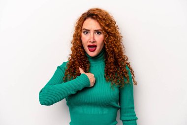 Beyaz arka planda izole edilmiş genç, beyaz tenli kadın parmağını gösterip gülümseyerek şaşırdı..