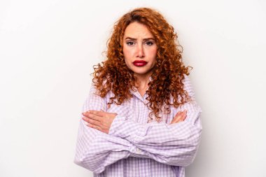 Beyaz arka planda soyutlanmış genç bir beyaz kadın omuzlarını silker ve gözleri açık kalır..