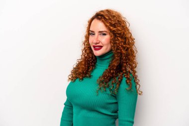 Beyaz arka planda izole edilmiş beyaz tenli genç bir kadın ellerini kalçasında tutuyor..