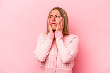 Pembe arka planda izole edilmiş genç beyaz kadın korkmuş ve korkmuş..