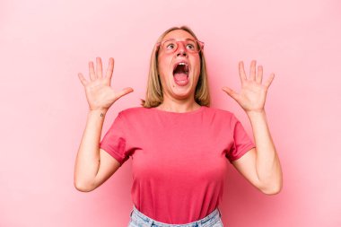 Pembe arka planda izole edilmiş genç beyaz kadın gökyüzüne haykırıyor, yukarı bakıyor, hayal kırıklığına uğramış..