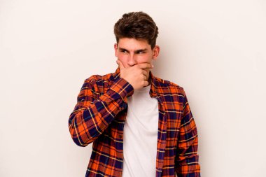 Beyaz arka planda izole edilmiş genç beyaz bir adam ağzı kapalı ve elleri endişeli görünüyor..