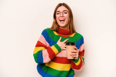 Beyaz arka planda izole edilmiş kahve taşıyan beyaz bir kadın elini göğsüne bastırarak kahkahalar atıyor..