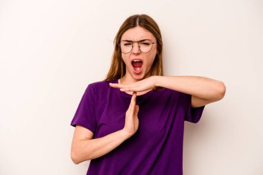 Beyaz arka planda izole edilmiş genç beyaz kadın bir mola hareketi gösteriyor..