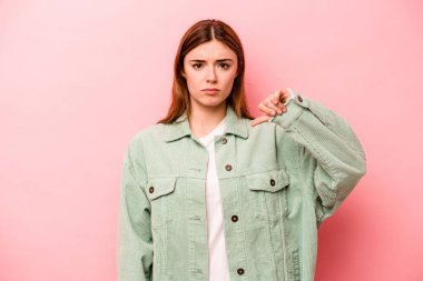 Pembe arka planda izole edilmiş genç beyaz bir kadın hoş olmayan bir jest gösteriyor. Anlaşmazlık konsepti.