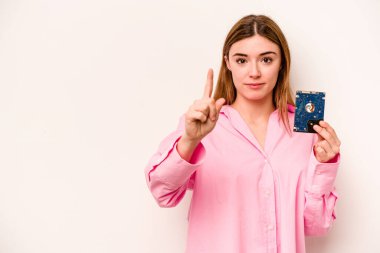 Beyaz arka planda izole edilmiş genç, gayri resmi beyaz kadın bir numarayı parmağıyla gösteriyor..