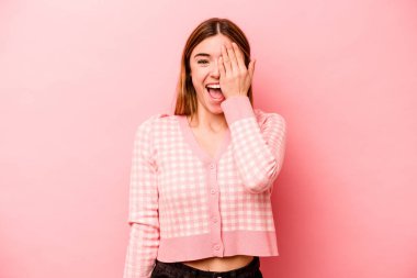 Pembe arka planda izole edilmiş beyaz bir kadın yüzünün yarısını palmiye ile örterek eğleniyor..