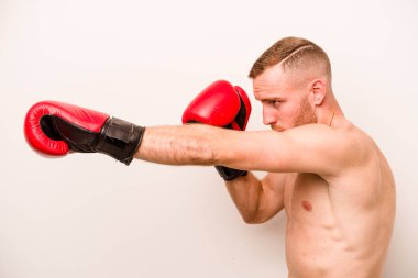 Beyaz arka planda boks yapan genç beyaz bir adam.