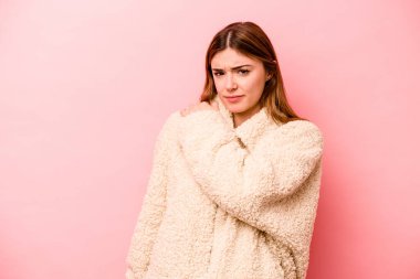 Pembe arka planda izole edilmiş, omuz ağrısı olan beyaz bir kadın..