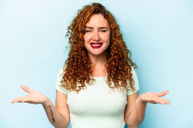 Mavi arka planda soyutlanmış genç, beyaz bir kadın kollarıyla ölçek oluşturuyor, mutlu ve kendinden emin hissediyor..