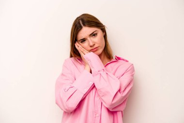 Beyaz arka planda izole edilmiş genç beyaz kadın esniyor. Ağzı eliyle kapatan yorgun bir hareket sergiliyor..