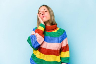 Mavi arka planda soyutlanmış, sıkılmış, yorgun ve dinlenmeye ihtiyacı olan beyaz bir kadın..