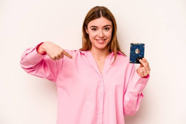 Beyaz arka planda izole edilmiş genç, gayri resmi beyaz bir kadın gömlek fotokopi alanını işaret ediyor, gururlu ve kendinden emin.