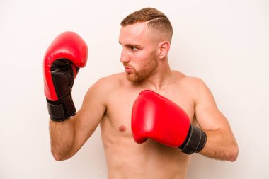 Beyaz arka planda boks yapan genç beyaz bir adam.