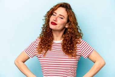 Genç, beyaz, mavi arka planda izole bir kadın. Amaçlarına ve amaçlarına ulaşma hayali kuruyor.