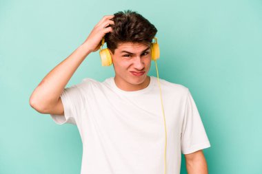 Mavi arka planda izole edilmiş müzik dinleyen genç beyaz adam şok oldu, o önemli bir toplantı hatırladı.