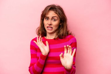Pembe arka planda izole edilmiş beyaz bir kadın. İğrenme belirtisi gösteren birini reddediyor..