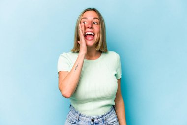 Mavi arka planda izole edilmiş beyaz bir kadın heyecanlı bir şekilde bağırıyor..